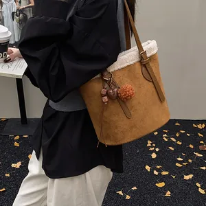 Detail der braunen Wildleder-Beuteltasche mit Lammfellbesatz und weichem Herzanhänger