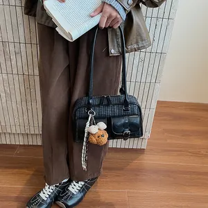 Detail of vintage gray plaid wool Boston bag featuring leather pockets and teddy bear charm