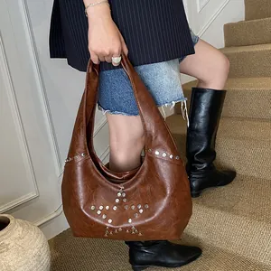 Detail of brown vintage hobo bag featuring silver metal star studs on premium PU leather