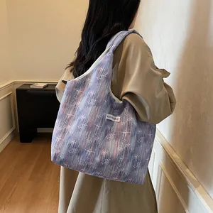 Detail of canvas tote bag featuring purple pink tie-dye pattern and white star motifs