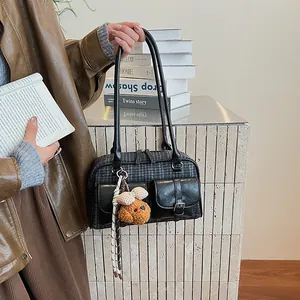 Close-up of retro plaid Boston bag featuring twin front pockets and a cute teddy charm