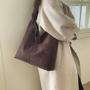 Vue macro du grand sac cabas en daim marron foncé montrant la texture et les coutures