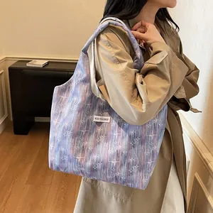Detail of canvas tote bag with starburst print and KISS YOURSELF woven label