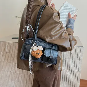 Detail of vintage grey plaid Boston bag with leather trim and cute bear keychain charm