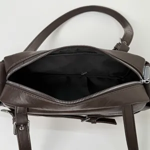 Interior view of brown vintage motorcycle bag with black lining and zipper pocket