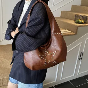 Close-up of vintage brown faux leather tote with silver star stud rivets and hobo style