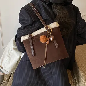 Detail der Vintage-Wildledertasche mit weißem Lammfellbesatz und Herz-Plüsch-Anhänger