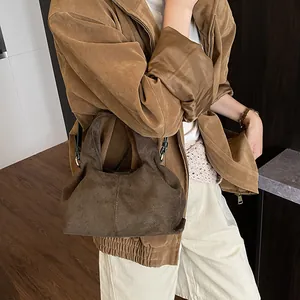 Detail of vintage brown suede handbag with soft pleats and premium leather shoulder strap