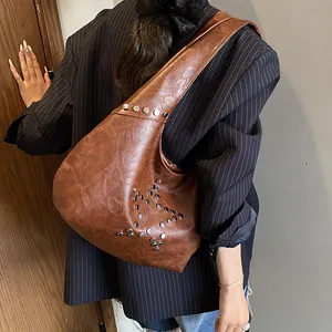 Detail of brown pleated leather shoulder bag with silver metal star rivet decorations