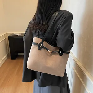 Détail du grand sac cabas montrant la texture en daim et le fermoir tournant doré