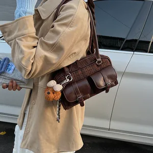 Close-up of retro plaid Boston bag with leather pockets and a cute bear charm