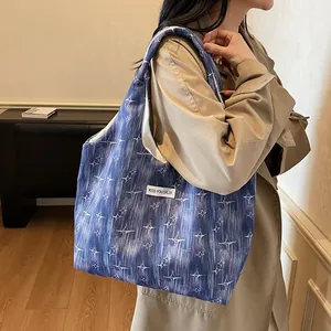 Close-up of blue star-patterned tote bag with white woven label on canvas fabric