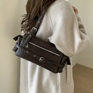Detailed close-up of dark brown vintage motorcycle style shoulder bag with silver buckles