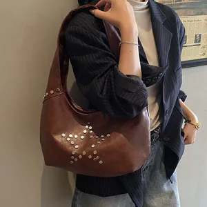 Detailed view of silver star rivets on a vintage brown leather Y2K punk shoulder bag