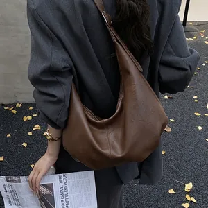 Vue détaillée du grand sac hobo marron foncé rétro avec texture cuir vintage et bandoulière
