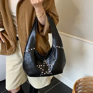 Close-up of black PU leather shoulder bag featuring silver star rivet studs