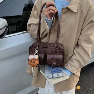 Detailed view of vintage plaid Boston bag with leather pockets and a cute puppy charm