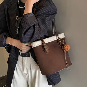 Detailansicht der braunen Wildledertasche mit weißem Lammfellbesatz und weichem Plüsch-Anhänger