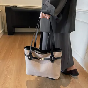 Détail du sac cabas vintage en tissu taupe avec anses en cuir noir et boucle en métal