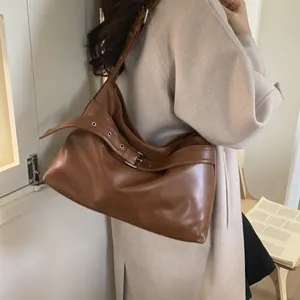 Detail of caramel brown large hobo bag with adjustable wide leather strap and metal eyelets
