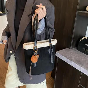 Detail der schwarzen Vintage-Wildledertasche mit weißem Kunstpelz und Plüsch-Herzanhänger