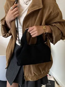 Elegant black suede satchel bag with top handle and crossbody strap for modern women