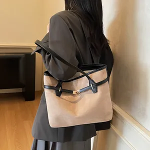 Détail du sac cabas en daim kaki avec bordures en cuir noir et boucle en métal doré chic