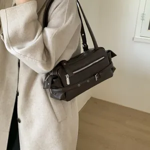 Detail of dark brown vintage motorcycle shoulder bag on beige wool coat with metal buckles