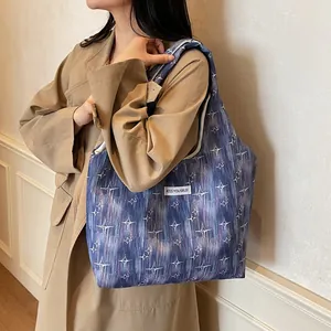 Blue-purple tie-dye tote bag with white stars shown in a chic street style outfit