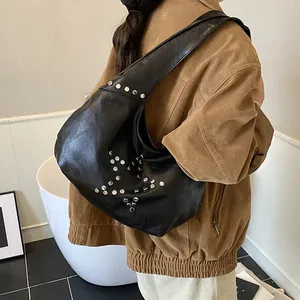 Detail of punk style black PU leather underarm bag with silver star rivet studs