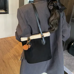 Detail der Wildleder-Beuteltasche mit weißem Plüschbesatz und Herzanhänger