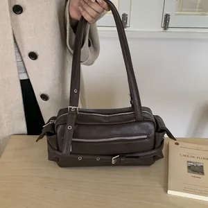 Close-up of dark brown PU leather shoulder bag with silver hardware and zipper details