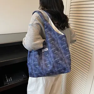 Model wearing dark blue tote bag with white star pattern and Kiss Yourself label