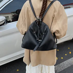 Close-up of black pleated leather texture and silver hardware on a casual backpack