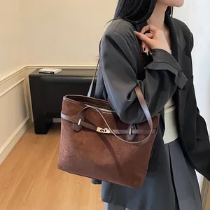 Détail d'un grand sac cabas marron vintage en daim avec boucle métallique élégante