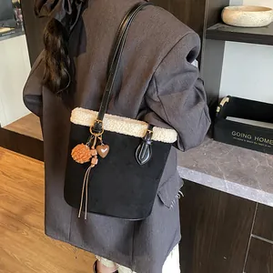 Detail einer schwarzen Wildleder-Eimertasche mit weißem Kunstpelz und Goldbeschlägen