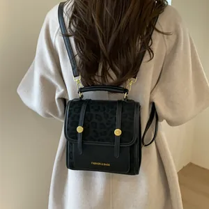 Détail d'un mini sac à dos en cuir avec rabat léopard et boucle magnétique dorée chic