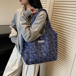 Detail of navy blue star pattern tote bag worn with casual sweatshirt for daily use