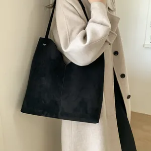 Vue détaillée du sac cabas noir mat en daim avec ouverture en V pour un style chic