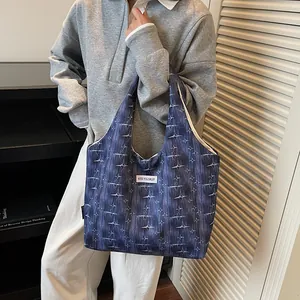 Close-up of a blue star-printed tote bag featuring a white Kiss Yourself label