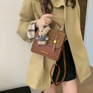 Détail latéral du sac patchwork marron avec imprimé léopard et breloque ours en peluche