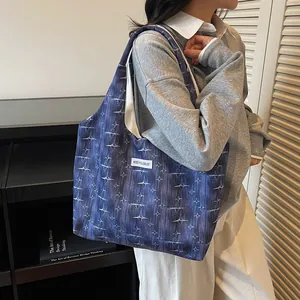 Detailed shot of navy canvas tote bag with light blue star pattern and woven label