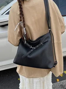 Large black pleated tote bag for women showing a stylish crossbody look on a model
