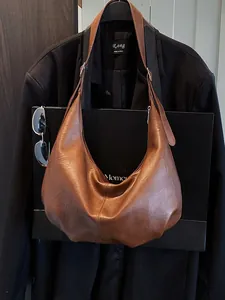 Sac hobo marron rétro pour femme présenté avec une tenue de ville professionnelle chic