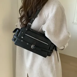 Detail of vintage biker shoulder bag with silver buckles and grommets on black leather