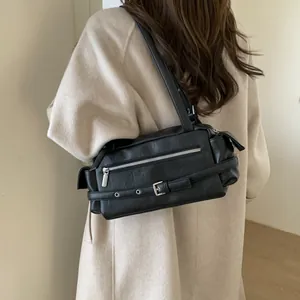 Detail of vintage biker shoulder bag in matte black leather with silver zipper accents