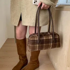 Détail du sac à carreaux vintage avec lanières en cuir marron pour l'automne-hiver