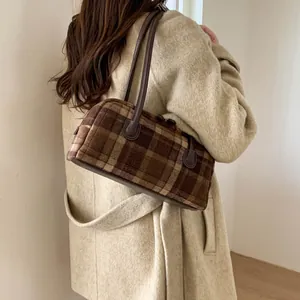 Détail du sac à main en laine à carreaux marron avec fines anses et style vintage anglais