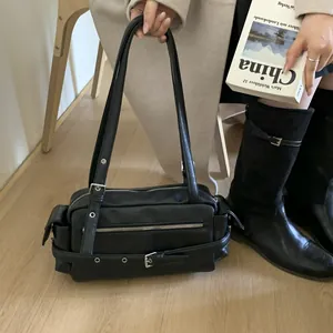 Detail of vintage black motor-style shoulder bag with silver buckles and zip features