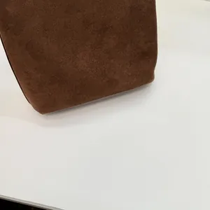 Detailansicht der braunen Wildledertasche mit Fokus auf Bodennaht und weiches Lederfinish